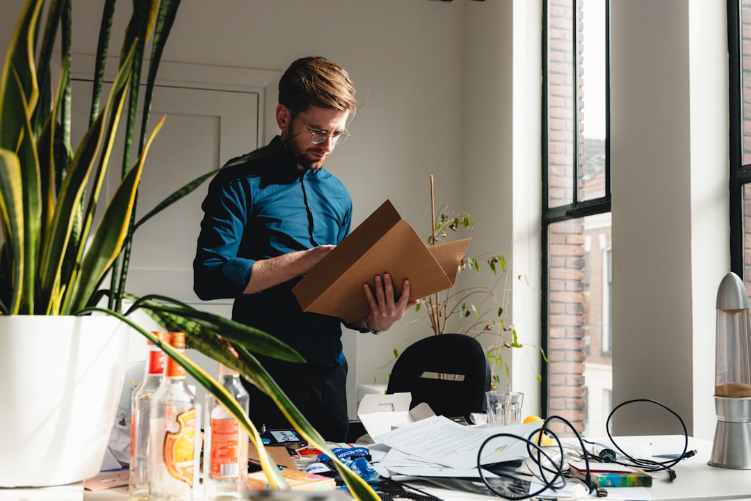A man cleaning out a desk and looking through the final bookkeeping of a closing business. The smell of bankruptcy lingering in the air.